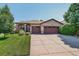 Well-maintained exterior featuring a three car garage, concrete driveway and green lawn at 8582 E 148Th Ln, Thornton, CO 80602