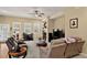 Cozy living room featuring a fireplace, ceiling fan and large windows for ample natural light at 8582 E 148Th Ln, Thornton, CO 80602