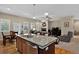 Living room flows into kitchen with center island and stainless steel appliances at 8582 E 148Th Ln, Thornton, CO 80602