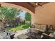 Enjoy outdoor relaxation on the covered patio with comfortable seating and serene backyard views at 8582 E 148Th Ln, Thornton, CO 80602