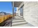 Stylish back porch featuring stone accents and a concrete patio with steps to the yard at 21185 E 62Nd Ave, Aurora, CO 80019