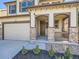 Two-story home with stone accents and attached garage at 10870 Unity Way, Commerce City, CO 80022