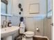 Stylish bathroom featuring a pedestal sink, toilet, and wood-look flooring at 14075 Deertrack Ln, Parker, CO 80134