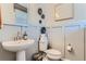 Modern bathroom with pedestal sink, toilet and gray wall paneling at 14075 Deertrack Ln, Parker, CO 80134