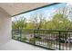 Balcony view surrounded by lush green trees and overlooking a neighborhood street at 550 E 12Th Ave # 209, Denver, CO 80203