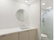Modern bathroom with sleek vanity, round mirror, and walk-in shower with glass enclosure at 550 E 12Th Ave # 209, Denver, CO 80203
