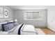 Bright bedroom featuring a bay window, light walls, plush bedding, and a door to the ensuite at 550 E 12Th Ave # 209, Denver, CO 80203