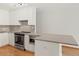 Bright kitchen featuring stainless steel appliances, mosaic tile backsplash and modern white cabinetry at 550 E 12Th Ave # 209, Denver, CO 80203
