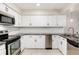 Modern kitchen with white cabinets, granite countertops, and stainless steel appliances at 6100 W Mansfield Ave # 24, Denver, CO 80235