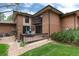 Brick building with a patio, grassy area, and trees in the background at 6100 W Mansfield Ave # 24, Denver, CO 80235