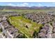 Aerial view of homes in a neighborhood with a large green space and mountain views in the background at 8487 S Nelson St, Littleton, CO 80127