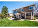 Backyard with patio, outdoor dining set, well-manicured lawn, and mature trees at 8487 S Nelson St, Littleton, CO 80127