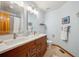 Bright bathroom with double sink vanity, tiled floor, and matching framed mirrors at 8487 S Nelson St, Littleton, CO 80127