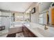 Large bathroom featuring dual sinks, soaking tub, stand up shower, and large mirror at 8487 S Nelson St, Littleton, CO 80127