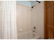 Bathroom with white tiled walls, bath tub, shower and white shower curtain at 8487 S Nelson St, Littleton, CO 80127