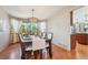 Bright dining area featuring hardwood floors, a modern chandelier, and large windows at 8487 S Nelson St, Littleton, CO 80127