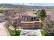 Aerial view of a two-story house with a well-maintained lawn, a three car garage, and mountain views at 8487 S Nelson St, Littleton, CO 80127