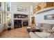 Bright living room featuring a fireplace with accent wall, hardwood floors, and a Juliet balcony at 8487 S Nelson St, Littleton, CO 80127