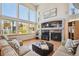 Bright living room featuring tall windows, fireplace with accent wall, and hardwood floors at 8487 S Nelson St, Littleton, CO 80127