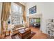 Bright living room featuring soaring windows, hardwood floors, and dining room access at 8487 S Nelson St, Littleton, CO 80127