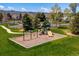 Outdoor community playground with swings and slides in a beautiful grassy setting, with seating for parents at 8487 S Nelson St, Littleton, CO 80127