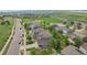 An aerial view displays homes with solar panels, green spaces, and community amenities, all set against a scenic landscape at 16226 W 94Th Dr, Arvada, CO 80007