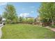 A well-maintained, green backyard with a wooden fence and lush landscaping provides a private outdoor space at 16226 W 94Th Dr, Arvada, CO 80007
