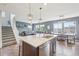 Open concept kitchen with stainless steel appliances, center island and hardwood floors at 16226 W 94Th Dr, Arvada, CO 80007
