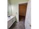 Bathroom featuring a vanity and a doorway to a closet with shelving, all carpeted at 14503 E Wagon Trail Dr, Aurora, CO 80015