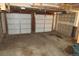 Spacious two-car garage with concrete floor and white doors at 14503 E Wagon Trail Dr, Aurora, CO 80015