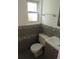 Modern powder room featuring decorative tile, floating shelves, and a window at 14503 E Wagon Trail Dr, Aurora, CO 80015