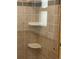 Shower with a glass door featuring neutral tile and corner shelves at 14503 E Wagon Trail Dr, Aurora, CO 80015