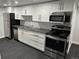 Modern kitchen with stainless steel appliances, dark countertop, and white cabinets at 2201 Lima St, Aurora, CO 80010