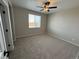 Bedroom with neutral carpet, ceiling fan, large window and neutral paint throughout at 9476 Yampa Ct, Commerce City, CO 80022