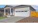 Charming single-Gathering home featuring a white garage door with windows and inviting covered porch at 9476 Yampa Ct, Commerce City, CO 80022