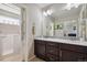 Bathroom with dual sink vanity, decorative tile backsplash and a walk-in tub through an open door at 15079 E Poundstone Pl, Aurora, CO 80015