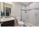 Modern bathroom featuring a glass-enclosed shower, white toilet, and vessel sink with updated fixtures at 15079 E Poundstone Pl, Aurora, CO 80015