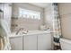 Bathroom features walk-in bathtub, window, and decorative tiled wall, with towel rack and accent pieces at 15079 E Poundstone Pl, Aurora, CO 80015