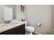 Cozy half bathroom featuring vanity with a dark wood cabinet and a decorative picture at 15079 E Poundstone Pl, Aurora, CO 80015