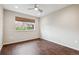 Bright bedroom with wood floor, ceiling fan, and a window overlooking the neighborhood at 15079 E Poundstone Pl, Aurora, CO 80015