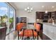 Bright dining area with a glass table, modern chandelier, and access to the outdoor patio at 15079 E Poundstone Pl, Aurora, CO 80015