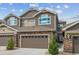 Beautiful townhouse showcasing a stone and shingle exterior, two-car garage, and well-maintained landscaping at 15079 E Poundstone Pl, Aurora, CO 80015