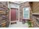 Inviting front entrance featuring a stylish door, stone accents, and colorful potted plants at 15079 E Poundstone Pl, Aurora, CO 80015