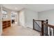 Upstairs hallway with carpeted floors, iron railing, and an open doorway leading to a bedroom at 15079 E Poundstone Pl, Aurora, CO 80015