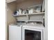 A laundry room with side by side washer and dryer, shelf with cleaning supplies and ironing board at 15079 E Poundstone Pl, Aurora, CO 80015