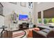 Bright living room with vaulted ceilings, a fireplace, custom shelving, and abundant natural light at 15079 E Poundstone Pl, Aurora, CO 80015