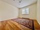 Empty bedroom with wood floors, a patterned rug, and a window letting in natural light at 3240 Folsom St, Boulder, CO 80304