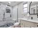 Modern bathroom featuring a shower with glass door, white vanity and black fixtures at 1724 W 40Th Ave, Denver, CO 80211