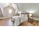 Bright bedroom with a slanted ceiling and access door, wood floors and headboard, and a full size bed at 1724 W 40Th Ave, Denver, CO 80211