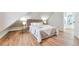 Bright bedroom with a slanted ceiling, wood floors and headboard, and a full size bed at 1724 W 40Th Ave, Denver, CO 80211